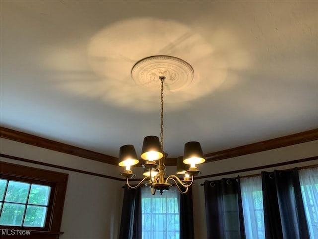 details featuring crown molding and a notable chandelier