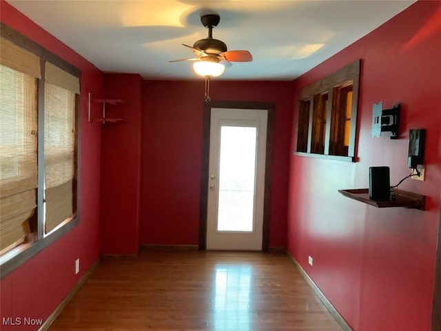 doorway featuring plenty of natural light, light hardwood / wood-style floors, and ceiling fan