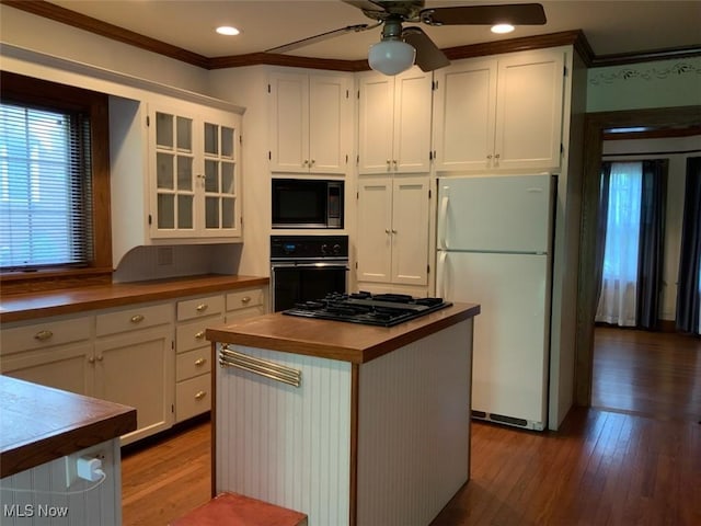 kitchen with butcher block counters, ceiling fan, a center island, white cabinets, and black appliances