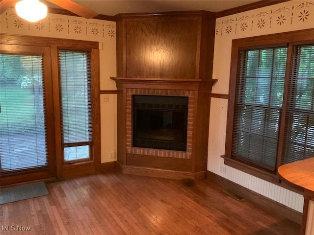 unfurnished living room with hardwood / wood-style flooring, ceiling fan, and a fireplace