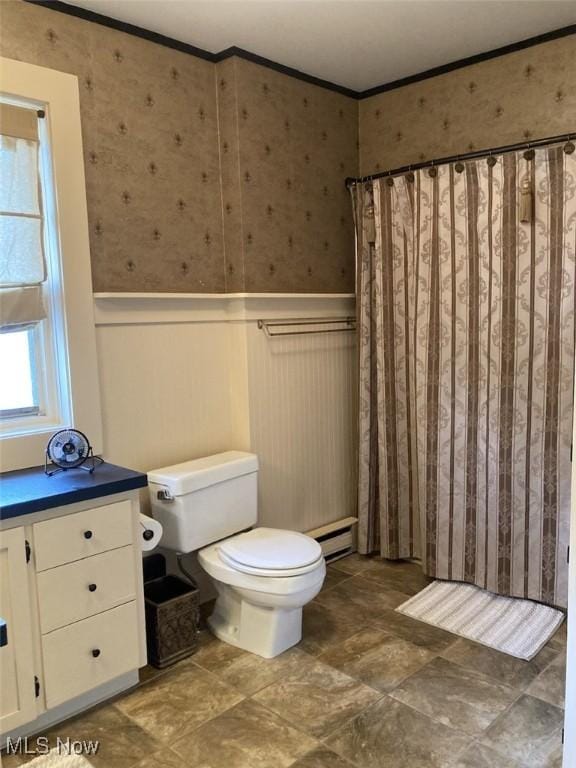 bathroom featuring baseboard heating, crown molding, and toilet