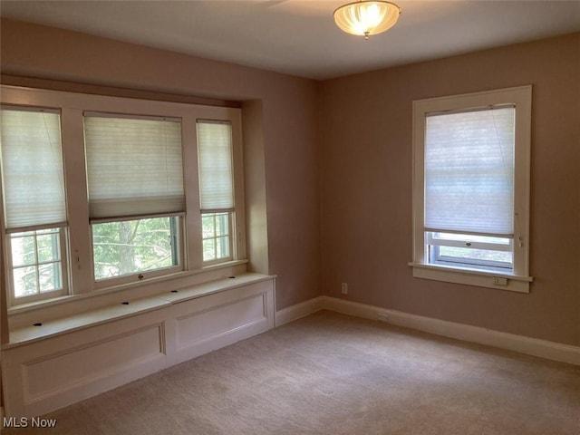 carpeted spare room with a healthy amount of sunlight