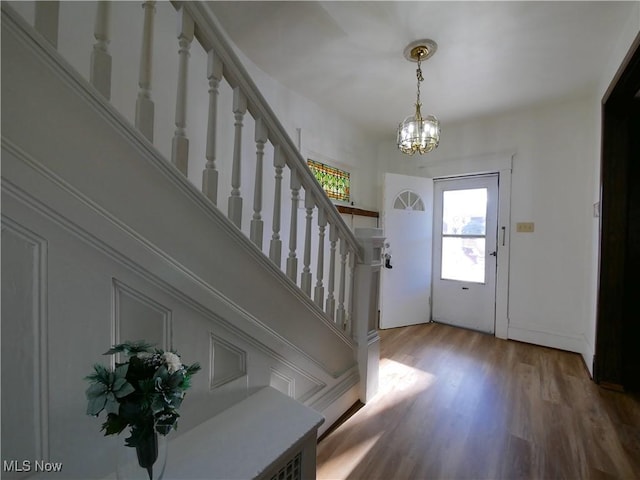 foyer entrance with wood-type flooring and a notable chandelier