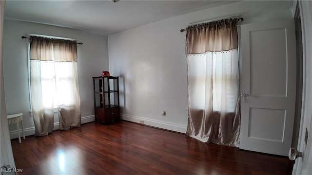 empty room featuring dark hardwood / wood-style floors and a healthy amount of sunlight