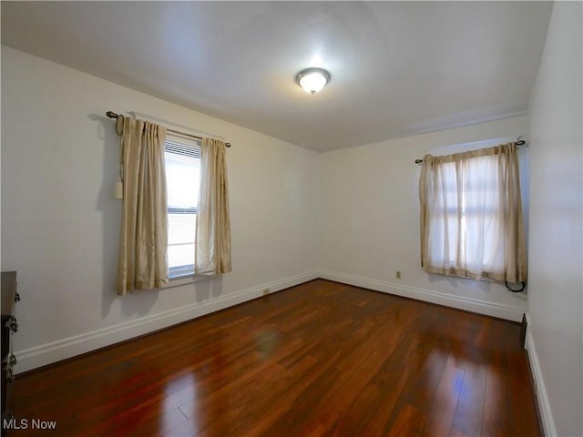 empty room with dark hardwood / wood-style flooring