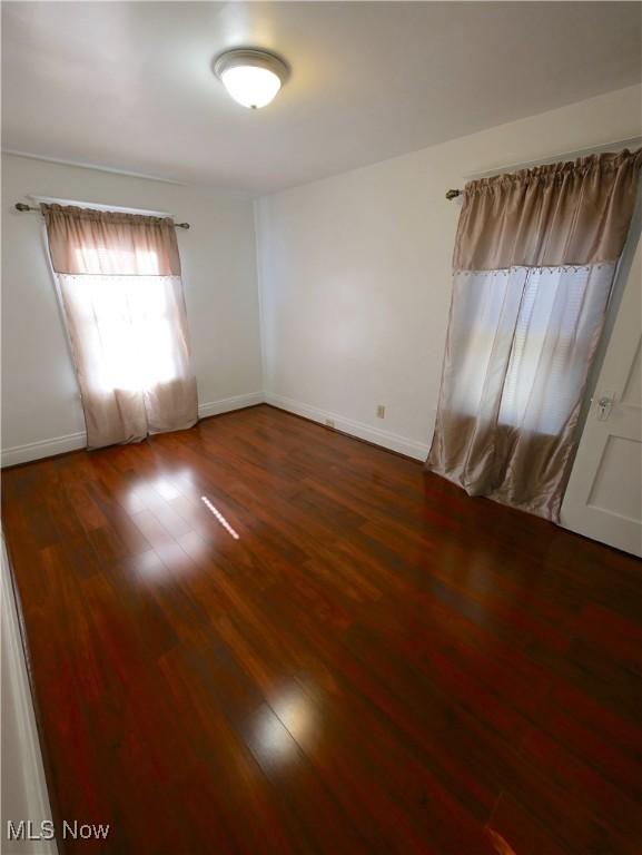 unfurnished room featuring dark wood-type flooring