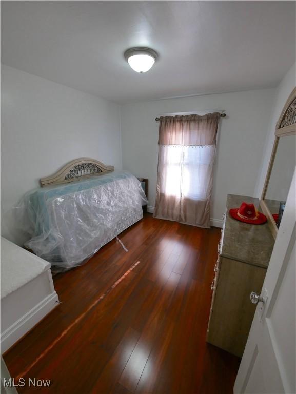 bedroom with dark hardwood / wood-style flooring