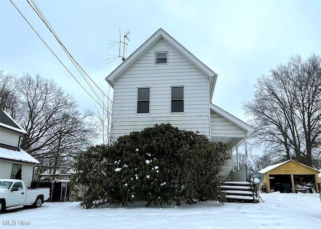 view of snow covered exterior with a carport