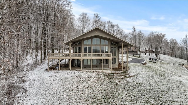 snow covered back of property featuring a wooden deck