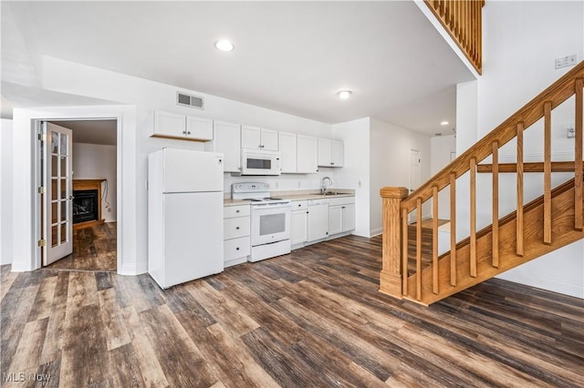 kitchen with white cabinets, white appliances, dark wood-type flooring, and sink