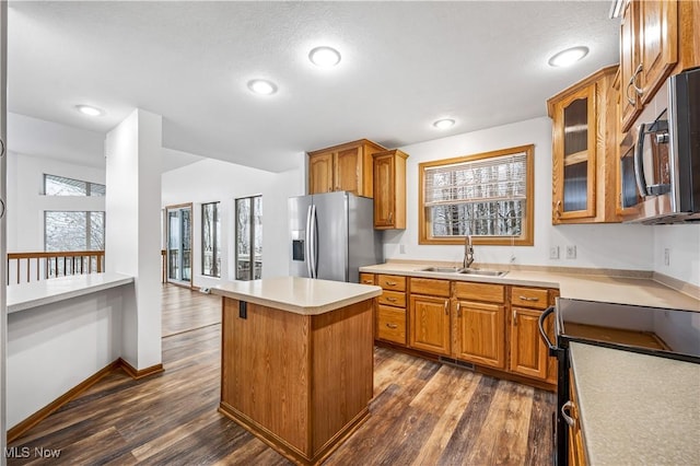 kitchen with a center island, dark wood-type flooring, sink, a wealth of natural light, and appliances with stainless steel finishes