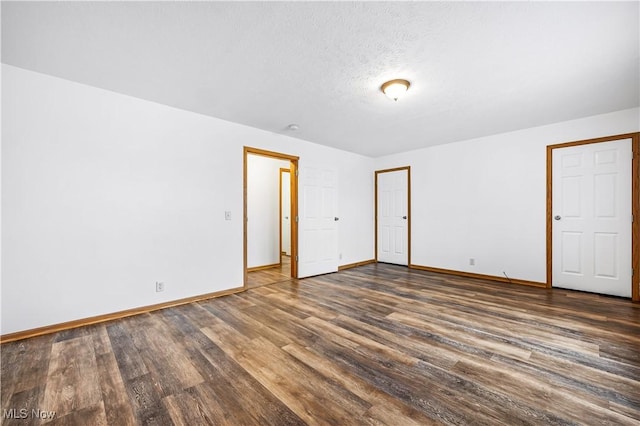 unfurnished bedroom featuring a textured ceiling and dark wood-type flooring