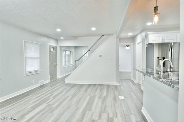 living room with light hardwood / wood-style flooring, ceiling fan, and sink