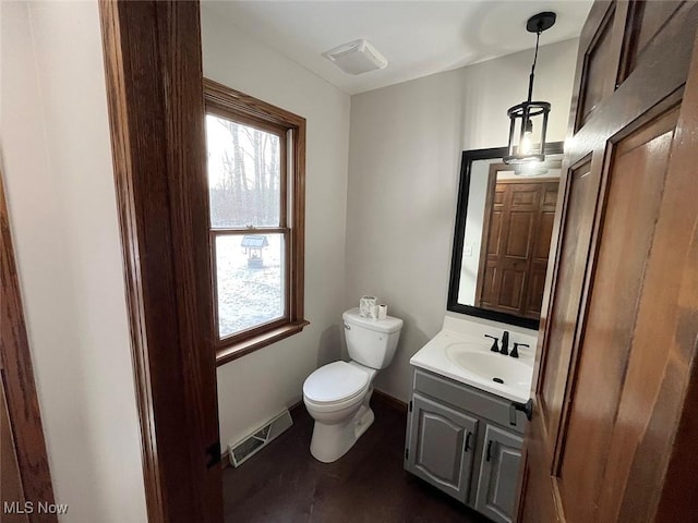 bathroom featuring vanity, wood-type flooring, and toilet