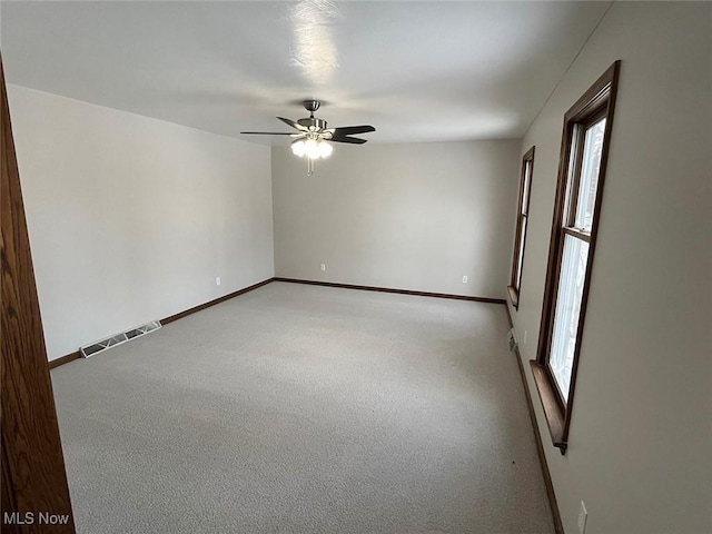 unfurnished room with ceiling fan and light carpet