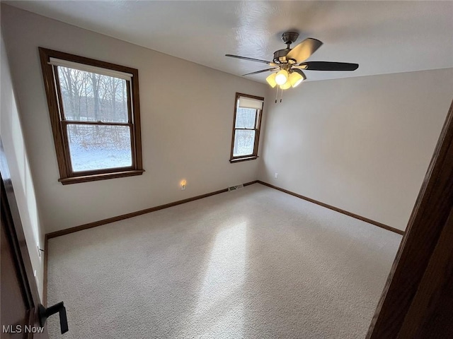 spare room with ceiling fan and plenty of natural light