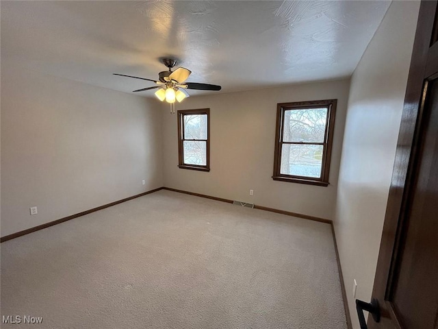 carpeted spare room with ceiling fan