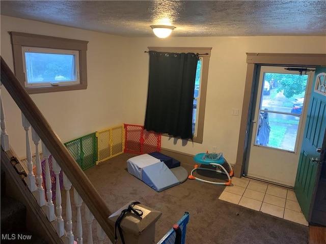 bedroom with multiple windows, light tile patterned floors, and a textured ceiling