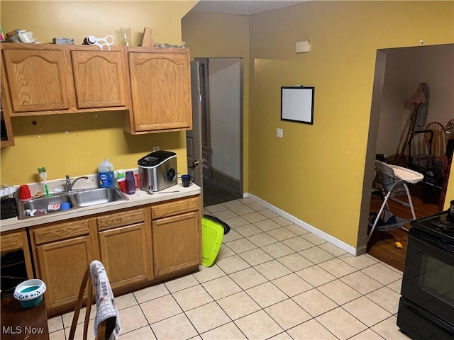 kitchen featuring light tile patterned floors, black / electric stove, and sink
