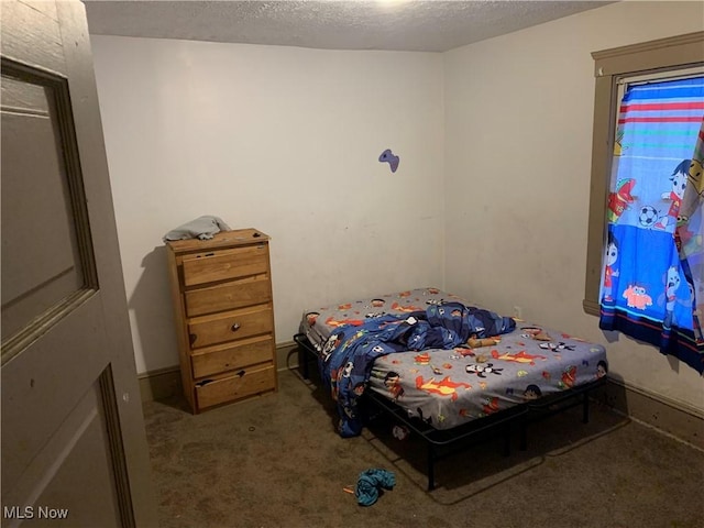 bedroom featuring carpet flooring and a textured ceiling