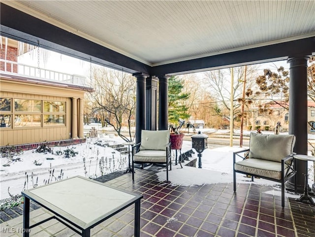 snow covered patio featuring covered porch