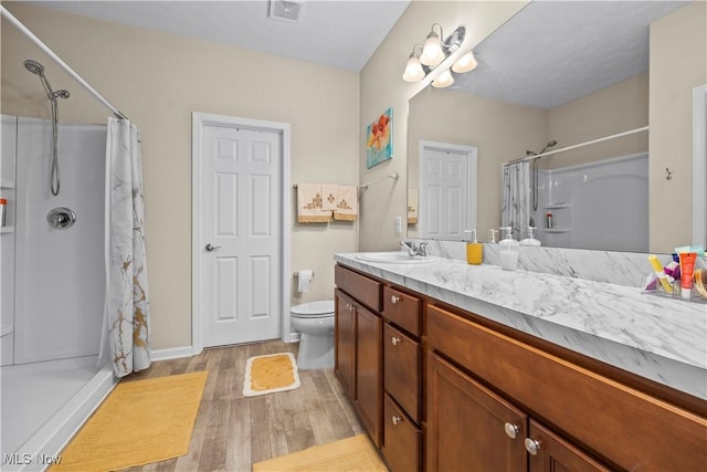 bathroom with vanity, hardwood / wood-style flooring, toilet, and walk in shower