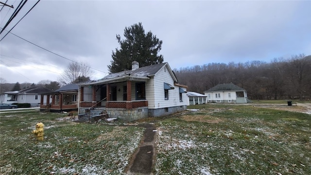 view of home's exterior with a lawn and a porch