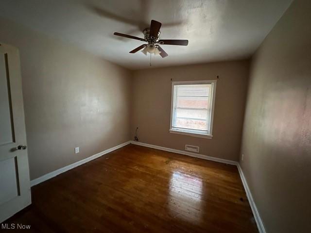 empty room featuring dark hardwood / wood-style flooring and ceiling fan