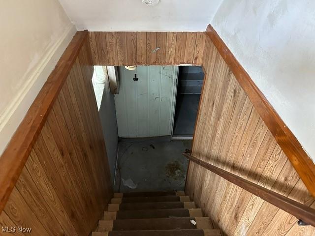 stairs featuring wood walls