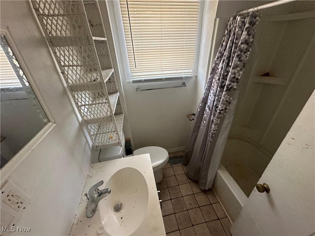 full bathroom featuring tile patterned floors, shower / tub combo with curtain, toilet, and sink