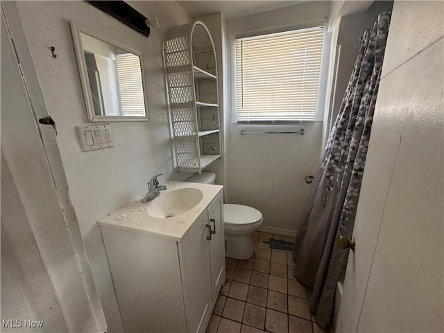 bathroom featuring tile patterned flooring, vanity, and toilet