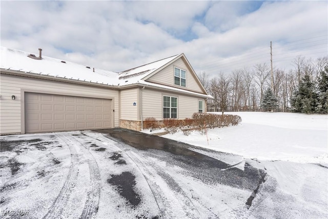 view of snow covered exterior featuring a garage