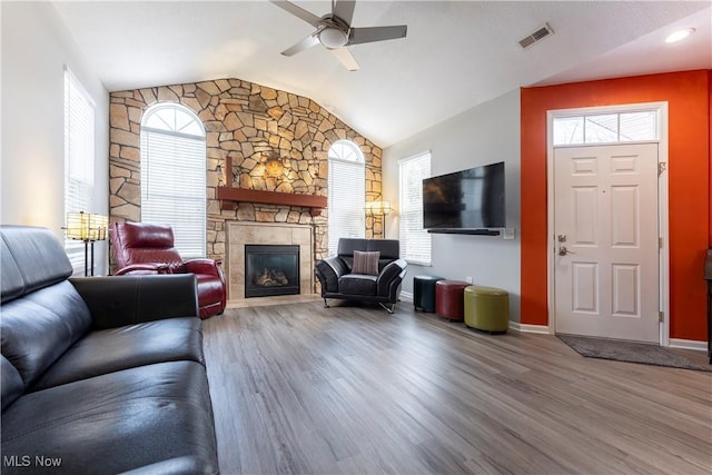 living room featuring hardwood / wood-style flooring, vaulted ceiling, ceiling fan, and a healthy amount of sunlight