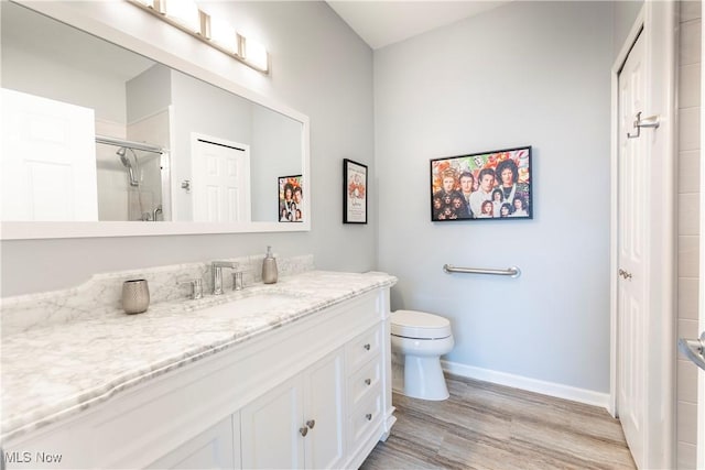 bathroom featuring hardwood / wood-style floors, toilet, an enclosed shower, and vanity