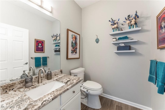 bathroom with hardwood / wood-style floors, vanity, and toilet