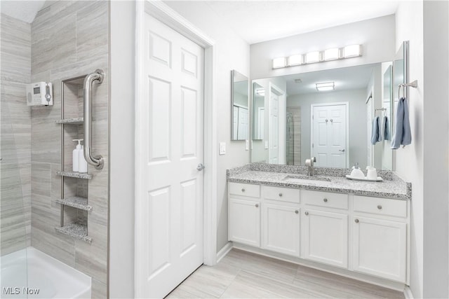 bathroom featuring a shower and vanity