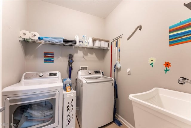 laundry room with washing machine and clothes dryer and sink