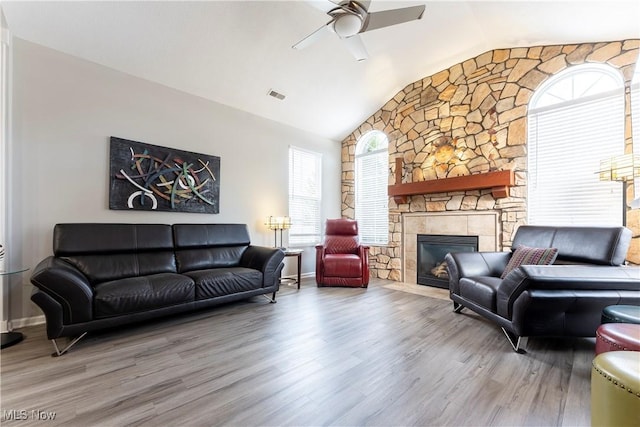 living room with hardwood / wood-style floors, ceiling fan, lofted ceiling, and a fireplace