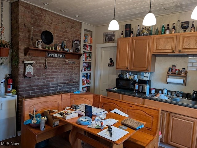 kitchen featuring tasteful backsplash, sink, brick wall, and decorative light fixtures