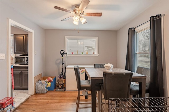 dining room with ceiling fan and light wood-type flooring