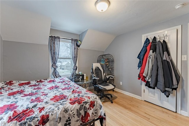 bedroom with hardwood / wood-style floors and vaulted ceiling