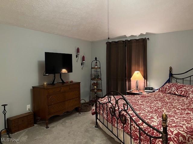 bedroom with light carpet and a textured ceiling