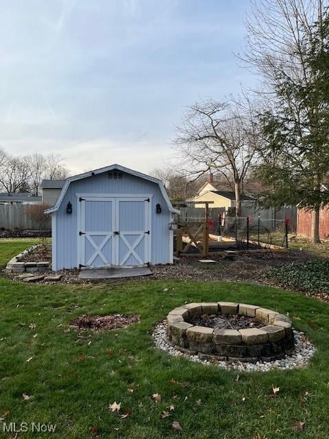 view of outdoor structure with a yard and a fire pit