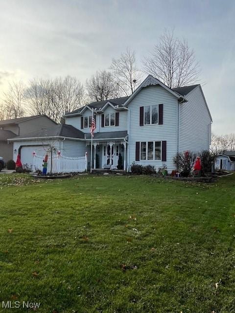 view of front property featuring a garage and a front yard