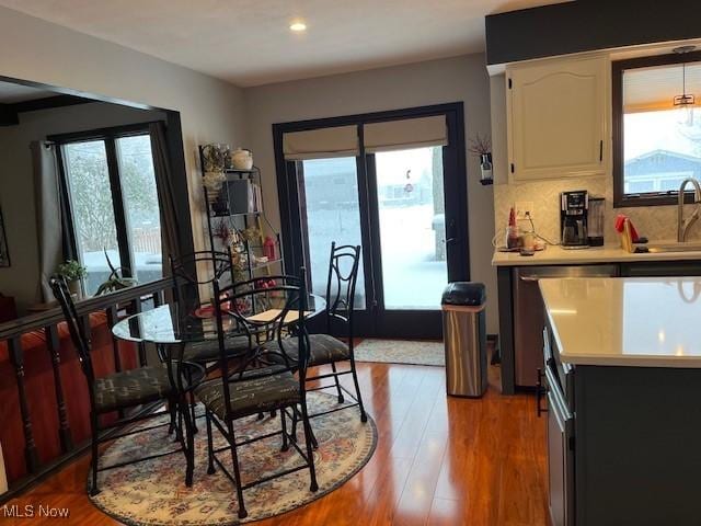 dining room with plenty of natural light, sink, and light wood-type flooring