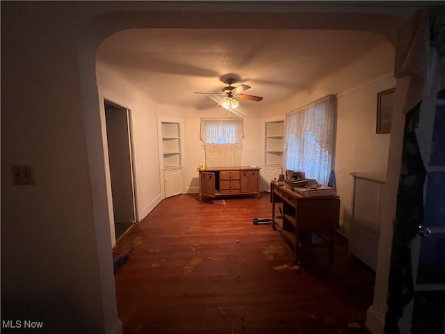 miscellaneous room with built in shelves, dark hardwood / wood-style flooring, and ceiling fan