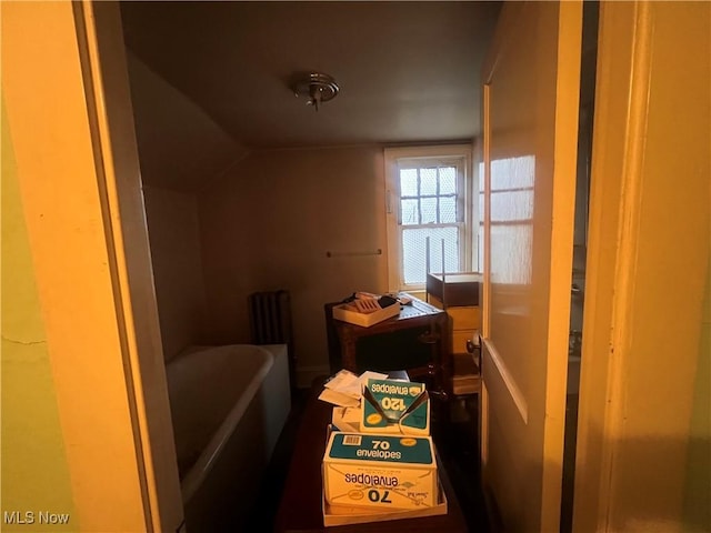 bathroom featuring a bathtub and lofted ceiling