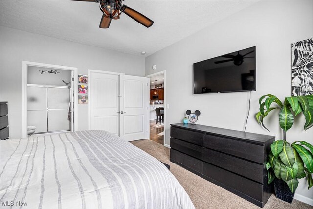 carpeted bedroom featuring a textured ceiling, ceiling fan, and ensuite bath