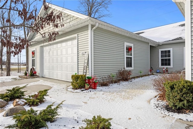 snow covered property featuring a garage