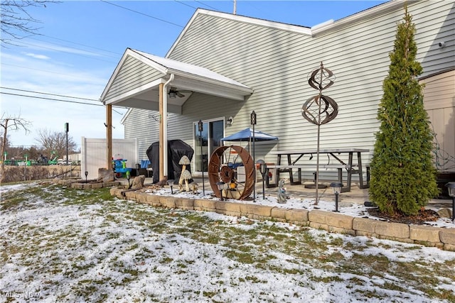 view of snow covered rear of property